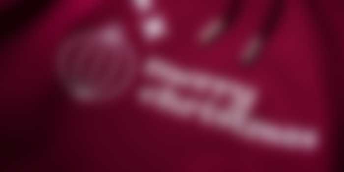 Close-up of embroidered Merry Christmas lettering and festive designs on bordeaux-coloured hoodie
